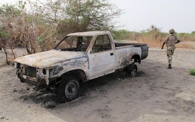 A soldier walks past a burnt vehicle during a military patrol in Hausari village, near Maiduguri, northern Nigeria, earlier this month.  Picture: REUTERS