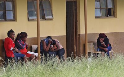 EMBARRASSED: Matric pupils at the Gxaba Secondary School in Ngqeleni, in the Eastern Cape, hide their faces from the camera last week after their school was named as being one of those under investigation for allegedly being implicated in group cheating. Picture: THE TIMES 
