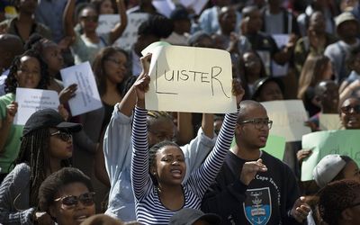 Students hold placards at a protest against alleged racism on campus brought to light by a documentary, Luister (Listen), in Stellenbosch on Tuesday. Picture: AFP PHOTO/RODGER BOSCH 