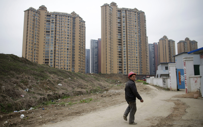 SKY’S THE LIMIT: A construction worker walks past residential compounds in Wuhan, in this file picture. Picture: REUTERS