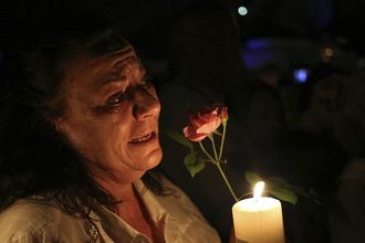 MOURNING: A women cries as she holds a candle and a flower outside former South African president Nelson Mandela's house in Houghton, Johannesburg, on Thursday. Picture: REUTERS