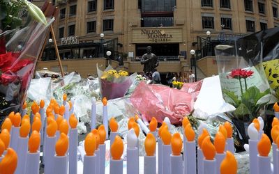 Flower are strewn in front of a statue of former president Nelson Mandela at Nelson Mandela Square in Sandton, Johannesburg. Picture: GCIS