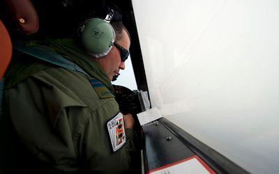 Royal Canadian Air Force Capt Mike MacSween looks out of an observation window on a Royal Australian Air Force AP-3C Orion this week as they fly over the southern Indian Ocean in the search for missing Malaysian Airlines flight MH370. Picture: REUTERS
