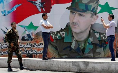 LOOK THIS WAY: A man takes a photo of his friend in front of a poster of Syria President Bashar al-Assad at Umayyad Square in Damascus. Syria is holding a presidential election for June 3, preparing the ground for Assad to extend his grip on power. Picture: REUTERS, KHALED AL-HARIRI