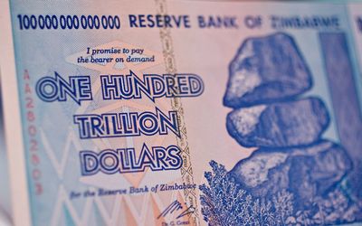 A one-hundred-trillion-dollar Zimbabwe note issued in 2008 is displayed in New York. A 10-year economic recession saw inflation rise to 500-billion percent in December 2008. Picture: BLOOMBERG/DANIEL ACKER 