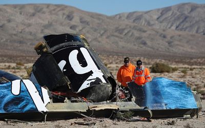 Sheriffs' deputies look at wreckage from the crash of Virgin Galactic's SpaceShipTwo near Cantil, California, on Sunday.  Picture: REUTERS 