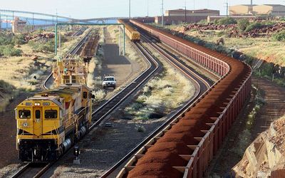 A train carrying iron ore in Australia. Brazil’s Vale plans to cut 25-million tonnes of higher-cost ore, but it may not be enough to boost short-term prices. Picture: AFP PHOTO/Greg WOOD