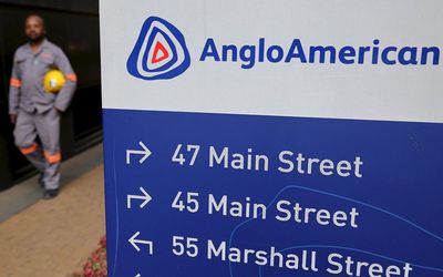 A worker walks past a board outside Anglo American offices in Johannesburg. Picture:  REUTERS/SIPHIWE SIBEKO