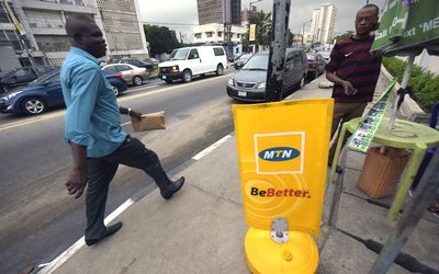A man passes an MTN board in Lagos, Nigeria. Reports on Thursday quoted an MTN Nigeria official as saying the Nigerian Communications Commission 'did not accept recommendations' that the fine was too heavy. Picture:  AFP PHOTO/PIUS UTOMI EKPEI