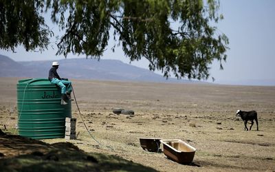 A farm worker sits on a water tank as he supplies his livestock with water at a farm outside Utrecht, a small town in the northwest of KwaZulu-Natal. Picture: REUTERS/SIPHIWE SIBEKO