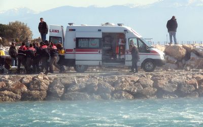Ambulance personnel ferrying migrants rescued at sea by a helicopter, to a waiting ambulance, in the Altinoluk district in Balikesir. Picture: AFP