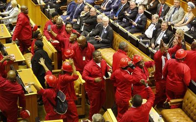 Opposition party leader Julius Malema, centre, of the Economic Freedom Fighters leaves the inside of Parliament with his members as President Jacob Zuma attempts to give his sate of the nation address in Cape Town on Thursday. Picture: EPA/SCHALK VAN ZUYDAM