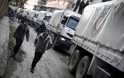 A Red Crescent convoy carrying humanitarian aid arrives ion the outskirts of the capital, Damascus, Syria, on Tuesday. Picture: AFP PHOTO/AMER ALMOHIBANY