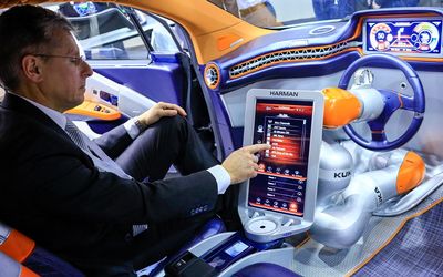 CONNECTED: A worker demonstrates the The Harman International Industries Rinspeed Budii concept car at the Mobile World Congress in Barcelona, Spain, on Monday. Picture: BLOOMBERG