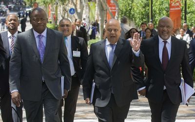 Finance Minister Pravin Gordhan, flanked by deputy minister Mcebisi Jonas, right, and Treasury director-general Lungisa Fuzile, left, and Deputy Finance Minister Mcebisi Jonas, arrive at Parliament  on Wednesday. Picture: TREVOR SAMSON