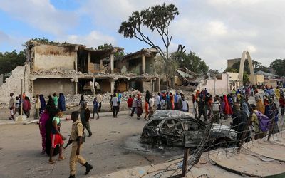 Residents gather to view the damage at the scene of a car bomb attack near Somali Youth League Hotel, known as SYL hotel, in Hamarweyne district in Mogadishu, on Saturday. Police say a similar bomb was responsible for the deaths of at least 30 in Baidoa on Sunday. REUTERS/FEISAL OMAR