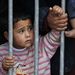 CONFINED:  A child at a fence near the Greece-Macedonia border, outside the village of Idomeni, Greece, on Wednesday. Picture: REUTERS/MARKO DJURICA