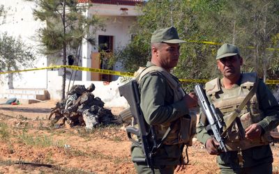 Tunisian soldiers stand guard at the scene of a gun battle outside the town of Ben Guerdane near the border with Libya. Picture: AFP  PHOTO/FATHI NASRI
