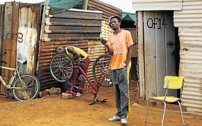 Thabo Mathambo, right, who helps  a friend fix  bicycles in Ikageng informal settlement in Tlokwe, says he has faith in the IEC to deliver a free and fair by-election in the district.  Picture: PUXLEY MAKGATHO