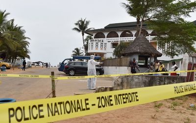 A police investigator walks in front of the Hotel Etoile du Sud in Grand Bassam, Ivory Coast, on Monday, a day after jihadist attackers stormed three hotels in the weekend resort. Picture: AFP PHOTO/ISSOUF SANOGO