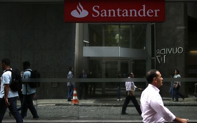 LATE:  People walk past a Rio de Janeiro branch of Banco Santander, the US car-financing company that has missed a deadline. Picture: REUTERS/PILAR OLIVARES