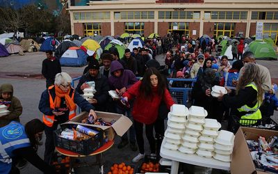 Refugees and migrants line up to receive food outside the temporary refugee facilities at the port of Piraeus, near Athens, Greece, 15 March 2016. Migration restrictions along the so-called Balkan route, the main path for migrants and refugees from the Middle East to the EU, has left thousands of migrants trapped in Greece.  Picture: EPA/ORESTIS PANAGIOTOU