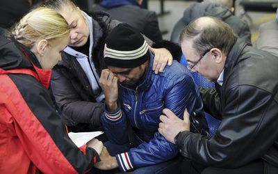 A psychologist of the Russian Emergencies Ministry, left, speaks with a relative, centre, of a victim of the crashed Flydubai Boeing 737-800 at the airport of Rostov-On-Don, Russia, on Saturday.  Picture: REUTERS