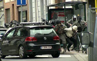 Armed Belgian police apprehend a suspect, in this still image taken from video, in Molenbeek, near Brussels, Belgium on Friday. Picture: REUTERS