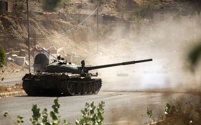 A Yemeni fighter loyal to Yemen's exiled President Abedrabbo Mansour Hadi, fires from a tank during clashes with Shiite Huthi rebels west of the city of Taez . Picture: AFP