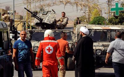 Lebanese army soldiers patrol as a Red Cross member walks near the site where suicide bomb attacks took place in the Christian village of Qaa, in the Bekaa valley, Lebanon on Monday. Picture: REUTERS/HASSAN ABDALLAH