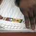 An Election Commission worker tears a ballot paper at a voting station during local municipal elections. Picture: EPA/KEVIN SUTHERLAND