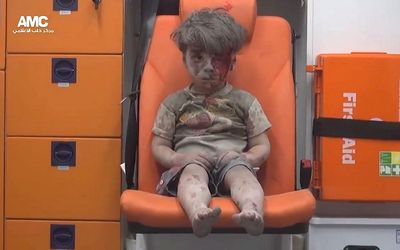 An injured child, named as Omar Daqneesh, awaits treatment in an ambulance after an air strike in Aleppo, Syria, on Wednesday. Picture: EPA/ALEPPO MEDIA CENTER