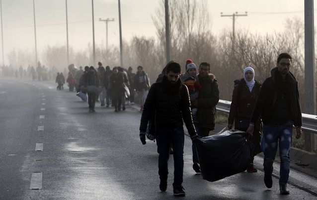 Migrants and refugees walk to cross the Greece-Macedonia border near the village of Idomeni, on Tuesday.  Picture: AFP PHOTO/SAKIS MITROLIDIS