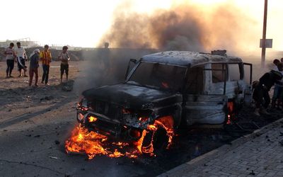 Yemenis gather beside a burning vehicle allegedly belonged to Houthi fighters following clashes with tribal militiamen loyal to Yemeni president Abdo Rabbo Mansour Hadi in the southern port city of Aden, Yemen, on Thursday. Picture: EPA/STRINGER