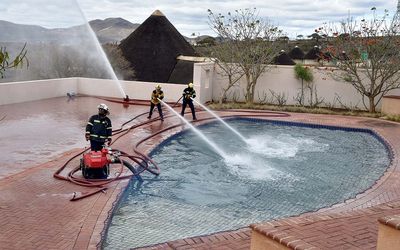 Emergency services staff give a demonstration of how to fight fire from the ‘fire pool’ on Sunday. Picture: DEPARTMENT OF COMMUNICATIONS