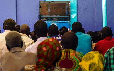 People follow a live transmission of the hearing of Lord’s Resistance Army rebel commander Dominic Ongwen, from the Lukodi disctrict of Gulu, northern Uganda, on Thursday. Picture: AFP PHOTO/ISAAC KASAMANI